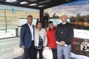 3 representatives from the Noongar Kaartdijin Aboriginal Corporation and Rod Garlett standing in the John Masters Bird Hide in front of the display of Noongar artwork.